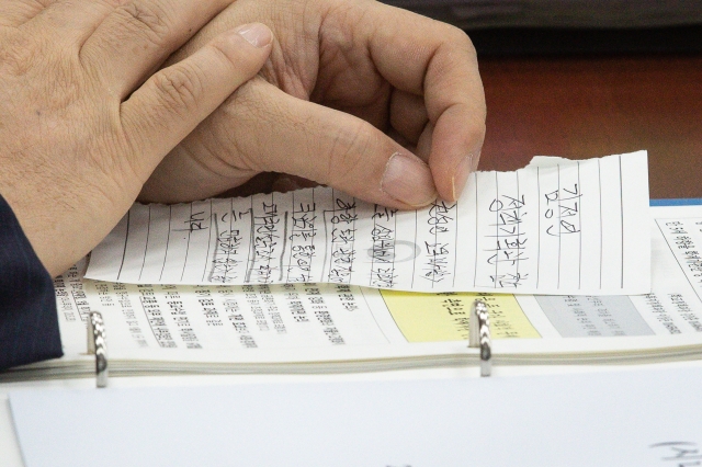 ▲장상윤 교육부 차관이 9일 오전 국회에서 열린 교육위원회 전체회의에 출석해 권성연 대통령실 교육비서관의 이름이 적힌 쪽지를 건네받고 있다. (연합뉴스)