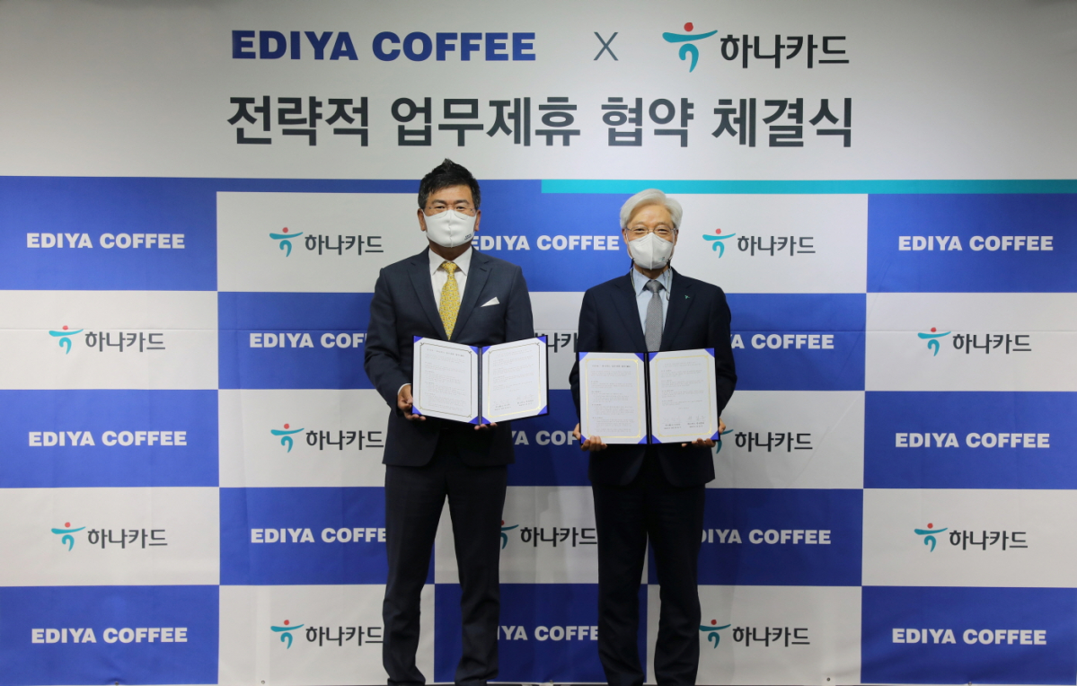 ▲10일 진행된 이디야커피-하나카드 전략적 업무제휴 협약 체결식에서 이디야커피 문창기 회장(왼쪽)과 하나카드 권길주 대표이사가 기념촬영을 하고 있다.  (사진제공=이디야커피)