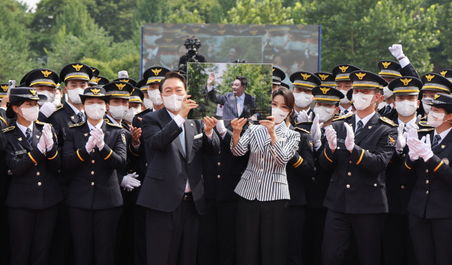 ▲윤석열 대통령과 김건희 여사가 19일 충북 충주시 중앙경찰학교에서 열린 310기 졸업식이 끝난 뒤 졸업생으로부터 받은 사진을 들고 기념촬영을 하고 있다.     