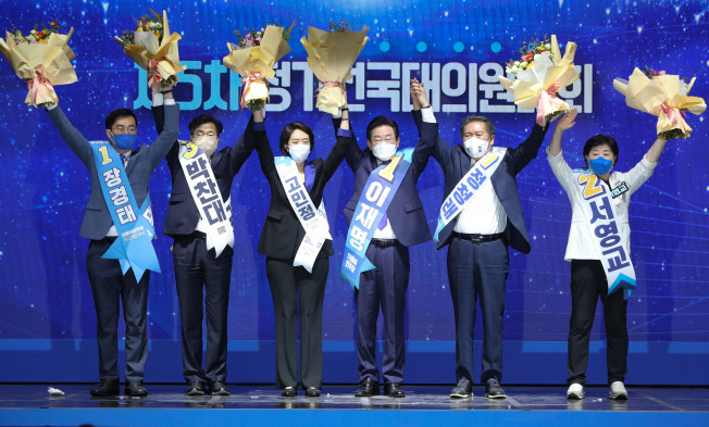 ▲더불어민주당 이재명 신임 당 대표와 최고위원들이 28일 서울 송파구 올림픽 체조경기장에서 열린 제5차 정기전국대의원대회에서 당대표와 최고위원으로 선출된 뒤 손을 맞잡아 들고 인사하고 있다. (왼쪽부터) 장경태, 박찬대, 고민정 최고위원, 이재명 대표, 정청래, 서영교 최고위원. (연합뉴스)