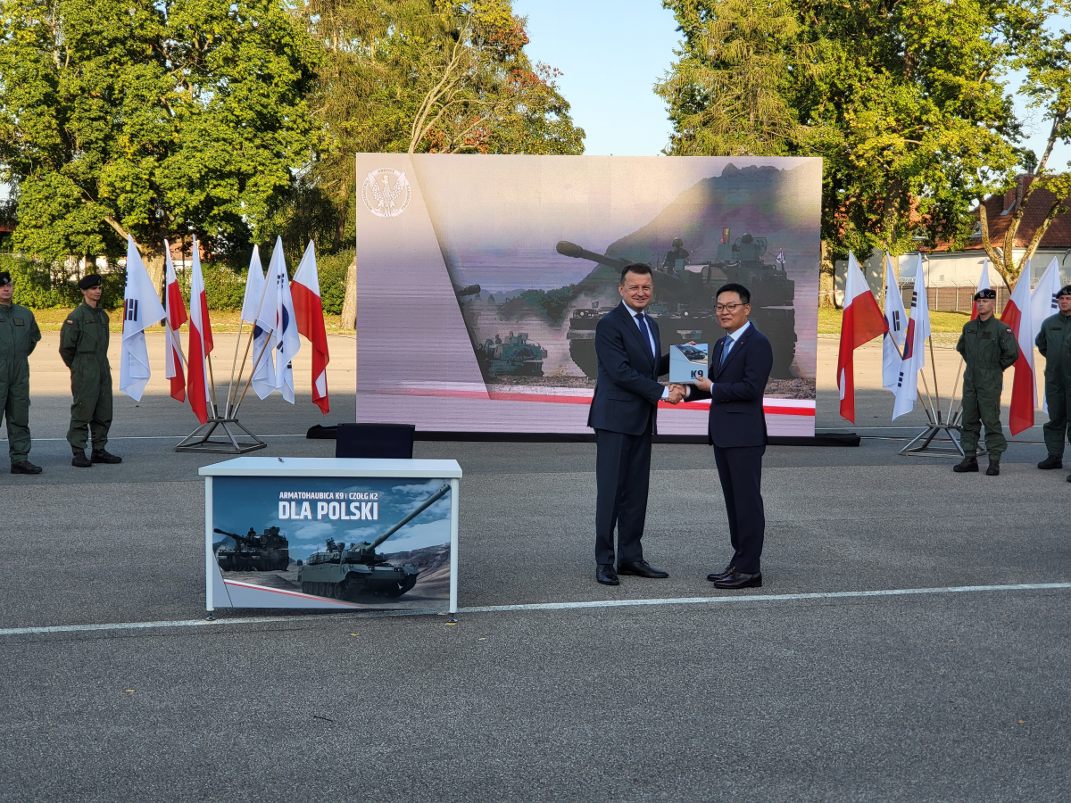 ▲폴란드 모롱크시 소재 기계화부대에서 열린 K9자주포 계약식에서 손재일 한화디펜스 대표이사(우)가 마리우시 브와슈차크 폴란드 국방부 장관과 악수하고 있다.