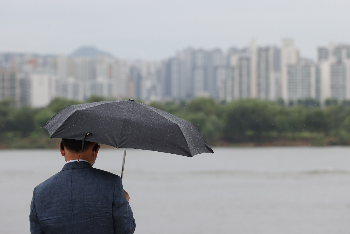 ▲전국 곳곳에 비가 내린 29일 서울 여의도 물빛광장분수 인근에서 우산을 쓴 시민이 한강을 바라보고 있다. (연합뉴스)