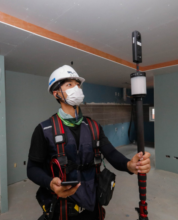 ▲DL이앤씨 직원이 360도 카메라를 활용해 공동주택 건설현장 내부를 촬영하고 있다. (사진제공=DL이앤씨)