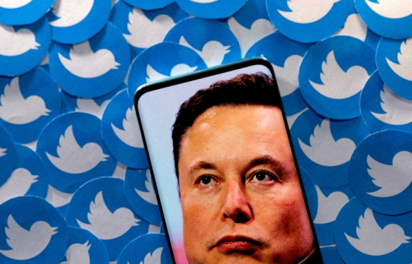 ▲일론 머스크 테슬라 최고경영자(CEO) 얼굴이 담긴 스마트폰이 트위터 로고들 위에 놓여 있다. 
 (로이터연합뉴스)