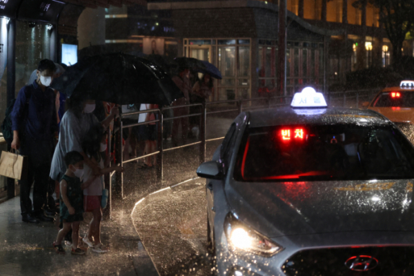 ▲폭우가 내린 8일 오후 시민들이 서울 용산구 용산역 인근 택시승차장에서 줄을 서 택시에 타고 있다. (연합뉴스)