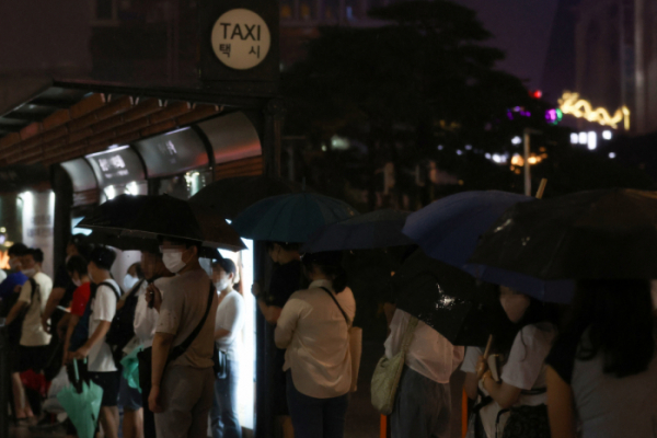 ▲폭우가 내린 8일 오후 시민들이 서울 용산구 용산역 인근 택시승차장에서 택시를 타기 위해 줄을 서고 있다. (연합뉴스)
