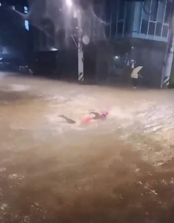 ▲8일 서울에 폭우가 쏟아진 가운데 관악구 신림동의 침수된 도로에서 한 남성이 수영하고 있는 모습이 포착됐다. (출처=온라인 커뮤니티 캡처)
