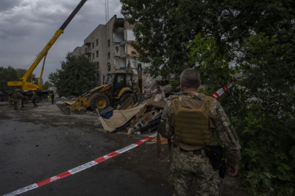 ▲우크라이나 군인이 7월 10일(현지시간) 동부 도네츠크의 차시브 야르에 러시아군의 로켓 공격으로 부서진 한 아파트 인근에서 현장을 바라보고 있다. AP뉴시스
