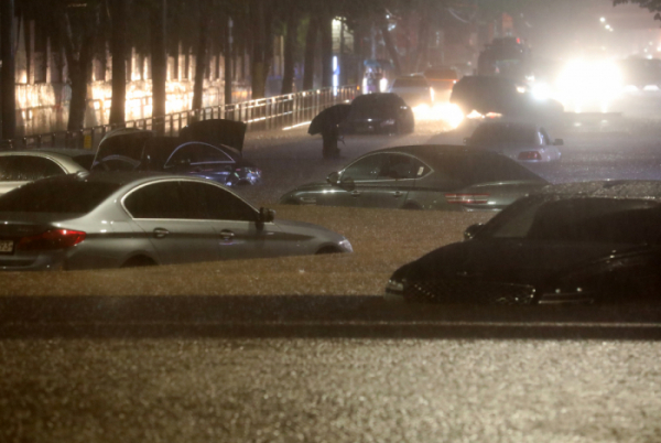 ▲수도권에 폭우가 내린 8일 오후 서울 강남구 일대 도로가 침수돼 차량이 잠겨 있다.  (뉴시스)