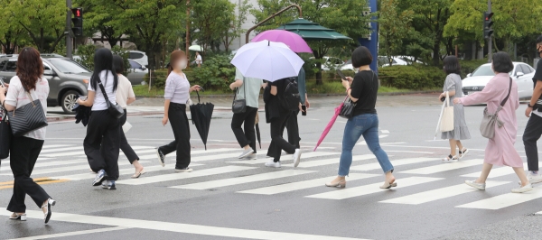 ▲(연합뉴스) 16일 오전 광주 서구 치평동에서 시민들이 빗줄기가 가늘어지자 우산을 접고 있다.
