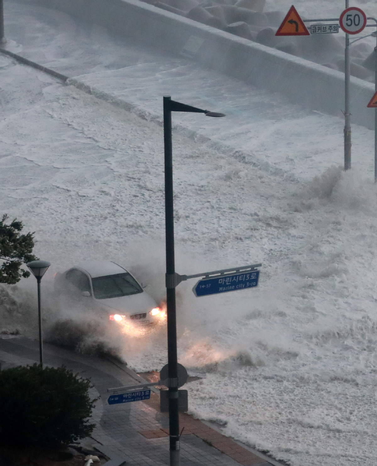 ▲6일 오전 제11호 태풍 힌남노가 상륙할 당시 부산 해운대구 마린시티에 거대한 파도가 차량을 덮치고 있다. (연합뉴스)