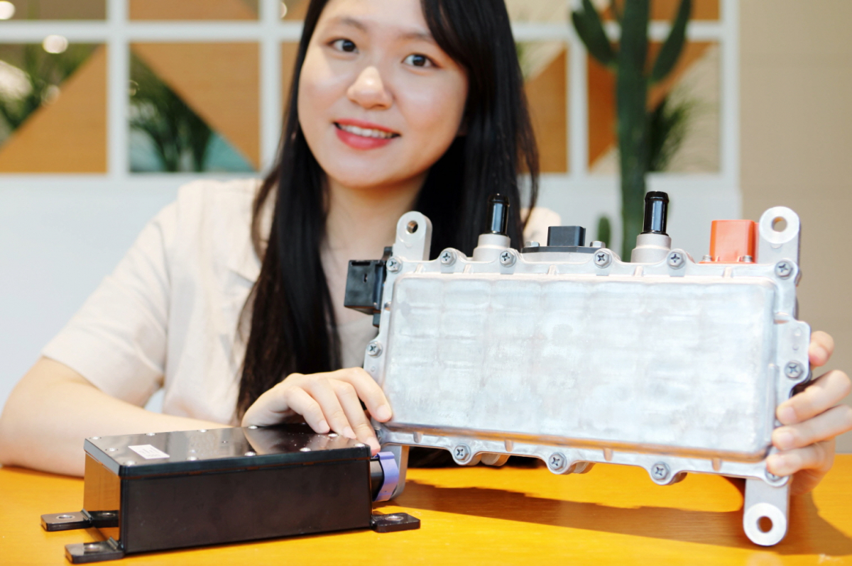 ▲LG이노텍 직원이 GM에 공급 중인 EVCC(사진 왼쪽)와 DC-DC 컨버터(사진 오른쪽)를 선보이고 있다.  (사진제공=LG이노텍)