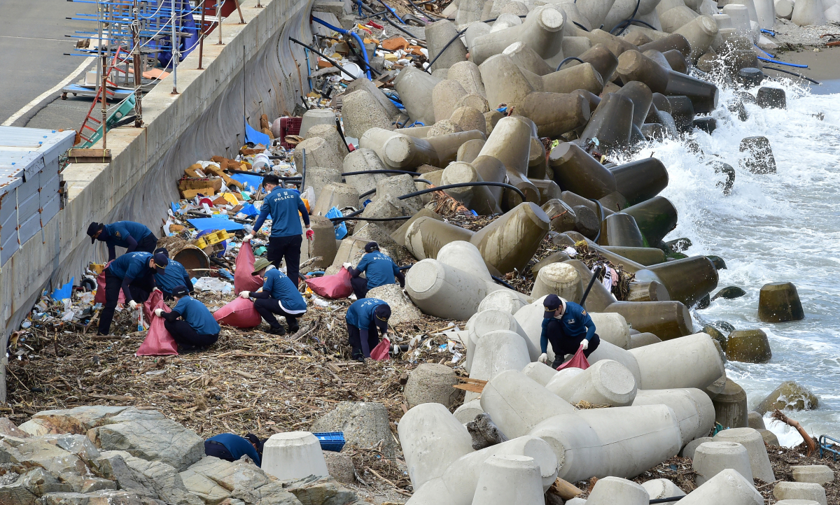 ▲13일 오후 포항시 남구 구룡포읍 병포리 해안가에서 대전경찰청 제3기동대 직원들이 태풍 힌남노로 인해 떠밀려온 쓰레기들을 줍고 있다. (뉴시스)