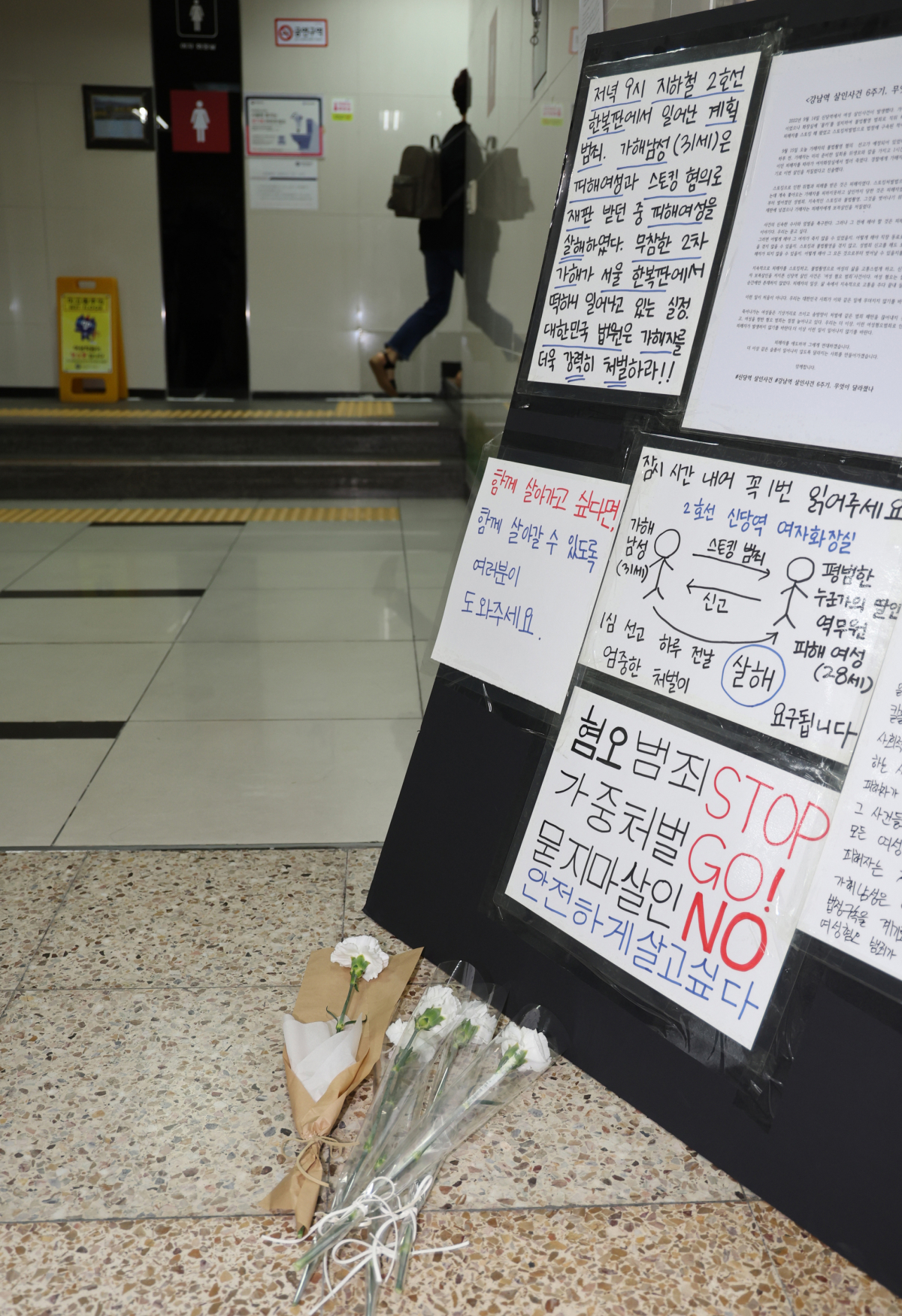 ▲15일 오후 20대 여성 역무원 살인사건이 벌어진 서울지하철 2호선 신당역 여자화장실 앞에 추모의 꽃과 혐오 범죄 중단을 촉구하는 글이 놓여 있다. (연합뉴스)