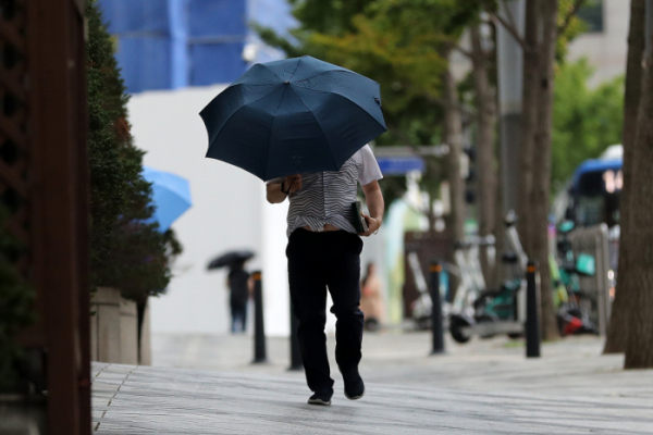 ▲비가 내린 16일 오후 서울 강남구 언주로 인근에서 한 시민이 우산을 쓰고 이동하고 있다.  (뉴시스)