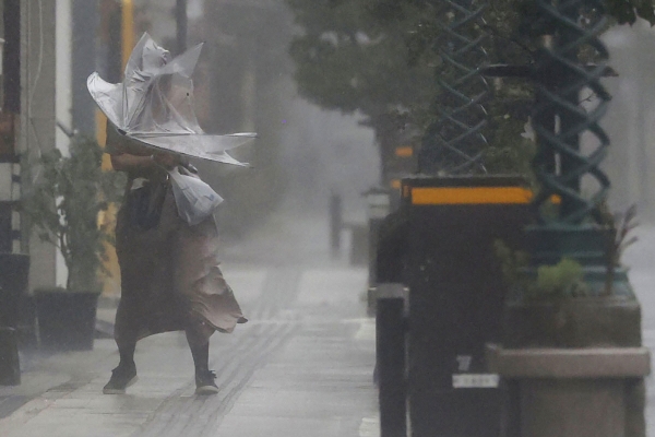 ▲일본 미야자키에서 18일 한 시민이 우산을 들고 버티고 있다. 미야자키/AP뉴시스
