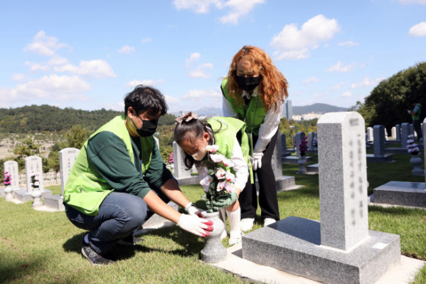 ▲현대엔지니어링 임직원 가족이 24일 국립서울현충원을 찾아 묘역 정화 봉사활동을 하고 있다.  (사진제공=현대엔지니어링)
