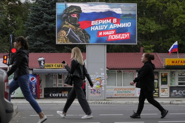 ▲우크라이나 루한스크에서 27일 시민들이 러시아군의 모습이 담긴 전광판 앞을 지나고 있다. 루한스크/AP뉴시스
