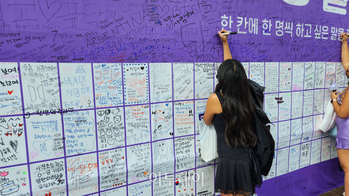 ▲15일 부산 아시아드주경기장 앞 홈플러스 아시아드점 입구에 전시된 BTS 멤버 지민의 생일 축하 게시판에 한 팬이 메시지를 적고 있다.  (조요한 PD yohan97@)