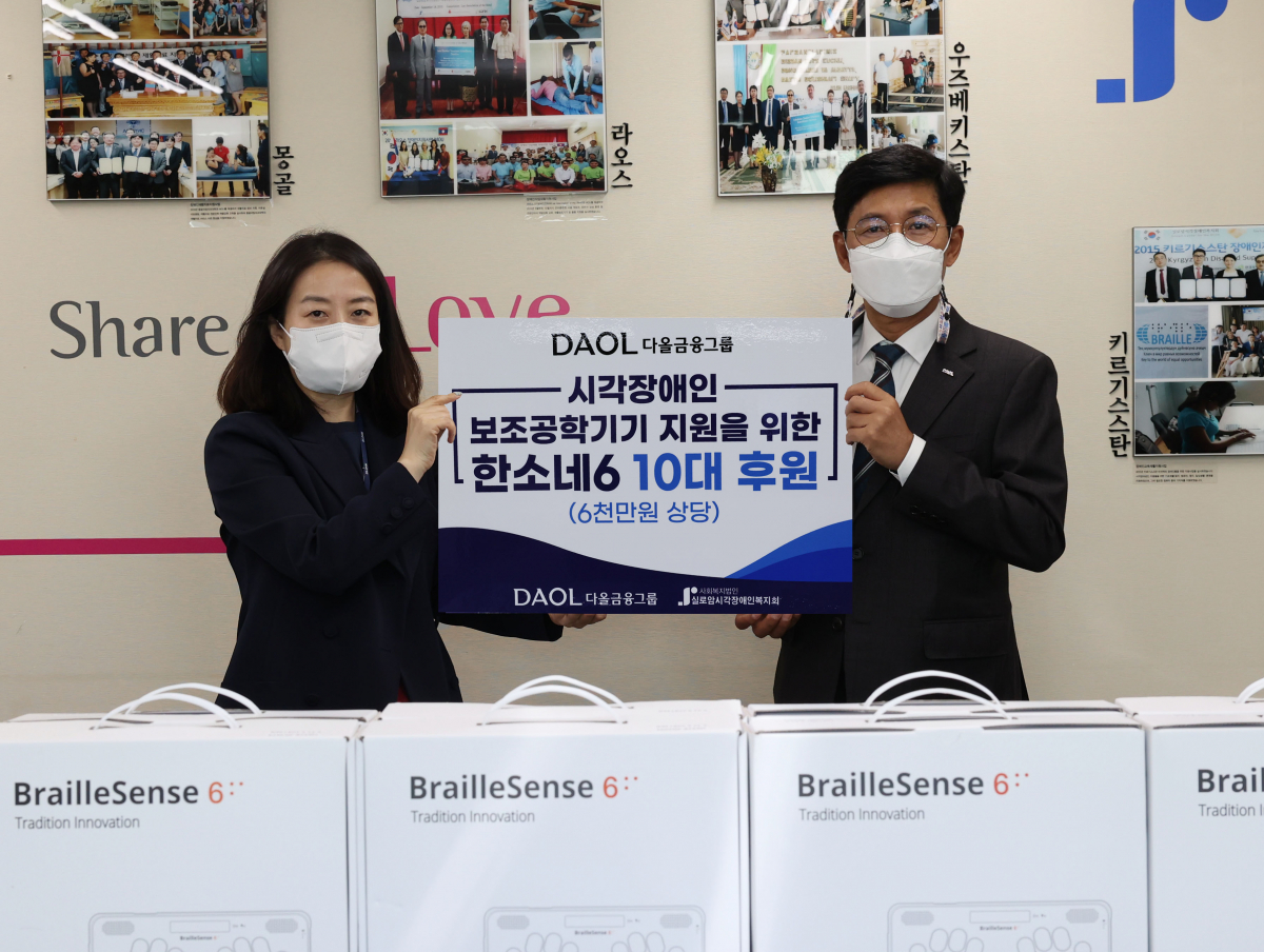 ▲19일 김미경 실로암시각장애인복지관 관장(왼쪽)과 다올금융그룹 최석종 부회장(오른쪽)이 시각장애인을 위한 점자정보단말기 10대를 전달하고 기념촬영을 하고 있다. (다올금융그룹 제공)