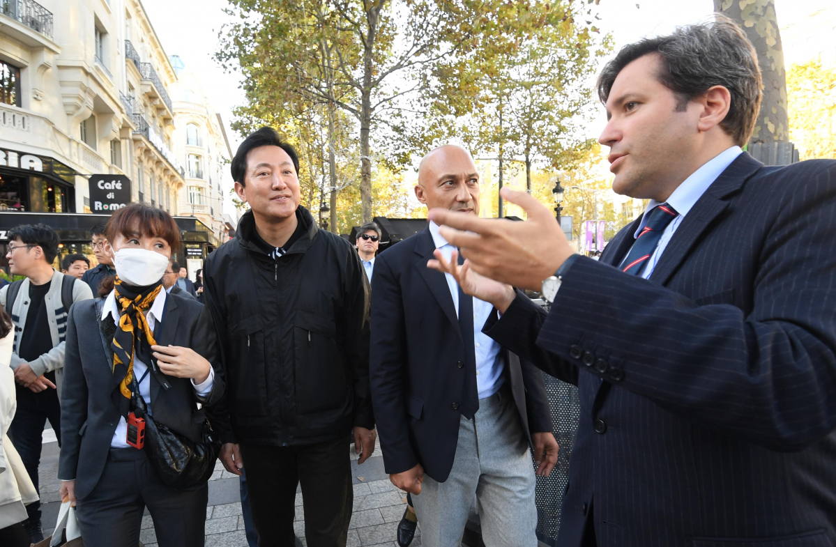 ▲오세훈 서울시장이 22일(현지시간) '파리8구역 도심 녹지축 조성' 사업 관계자들과 함께 샹젤리제 거리를 걸으며 이야기를 나누고 있다.  (사진제공=서울시)