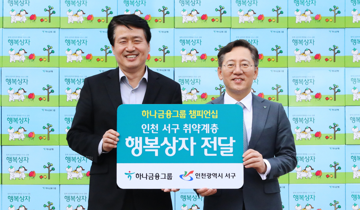 ▲박성호 하나은행장(오른쪽)이 27일 인천 서구청 앞에서 진행된 행복상자 전달식에서 강범석 인천 서구청장과 기념촬영을 하고 있다. (사진제공=하나금융그룹)