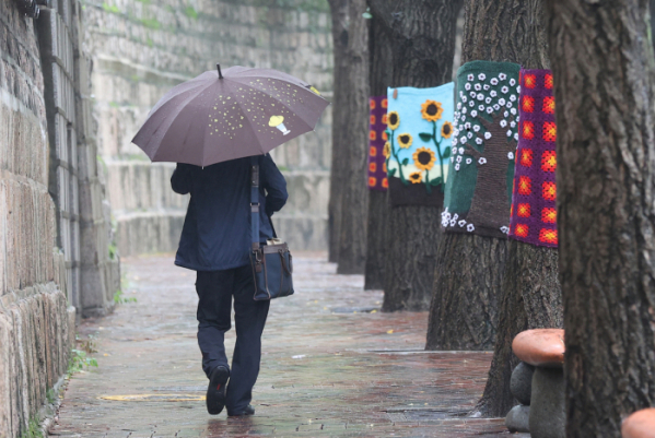 ▲중부지방에 비가 예보된 지난 3일 오전 서울 중구 덕수궁 인근에서 한 시민이 우산을 쓴 채 이동하고 있다. (연합뉴스)