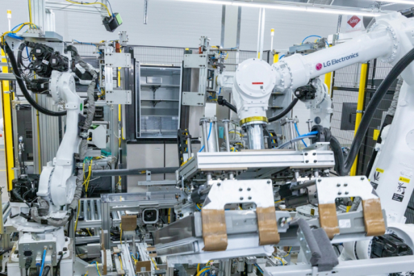 ▲LG스마트파크 통합생산동 생산라인에 설치된 로봇팔이 20kg이 넘는 냉장고 문을 본체에 조립하고 있다.  (사진제공=LG전자)
