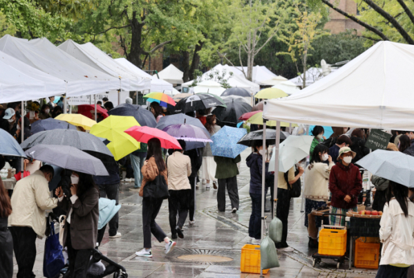 ▲비가 내리는 9일 오후 서울 종로구 마로니에 공원에서 열린 '마르쉐 농부시장'을 찾은 시민들이 우산을 쓰고 전시를 둘러보고 있다. (연합뉴스)