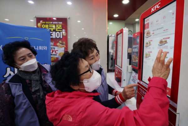 ▲11일 서울 강남구의 한 패스트푸드 체인점에서 한 어르신이 키오스크를 이용해 음식을 주문하는 방법을 배우고 있다.(이투데이DB)