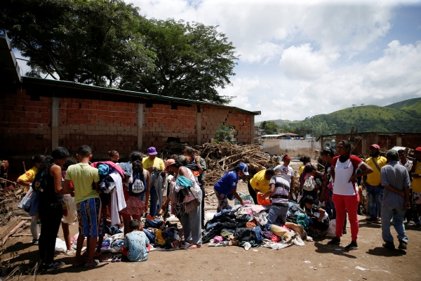 ▲11일(현지시간) 베네수엘라 라스 테헤리아스에서 최근 발생한 홍수와 산사태로 피해를 본 이재민들이 기증받은 옷들을 받아가고 있다. 라스 테헤리아스(베네수엘라)/로이터연합뉴스

