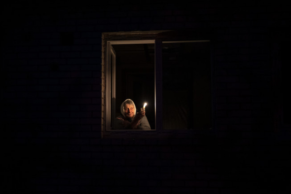 ▲20일 우크라이나 키이우의 한 지역에 사는 주민이 단전을 하는 동안 초를 켜고 있다. 키이우(우크라이나)/AP뉴시스