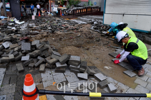 ▲;지난 8월 서울 동작구 신대방역 앞 보도블럭이 폭우로 인해 파손돼 관계자들이 복구작업을 하고 있다. 신태현 기자 holjjak@