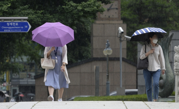 ▲갑작스런 소나기가 내린 13일 서울 중구 청계광장 인근에서 우산을 쓴 시민들이 발걸음을 재촉하고 있다. 조현호 기자 hyunho@ (이투데이DB)