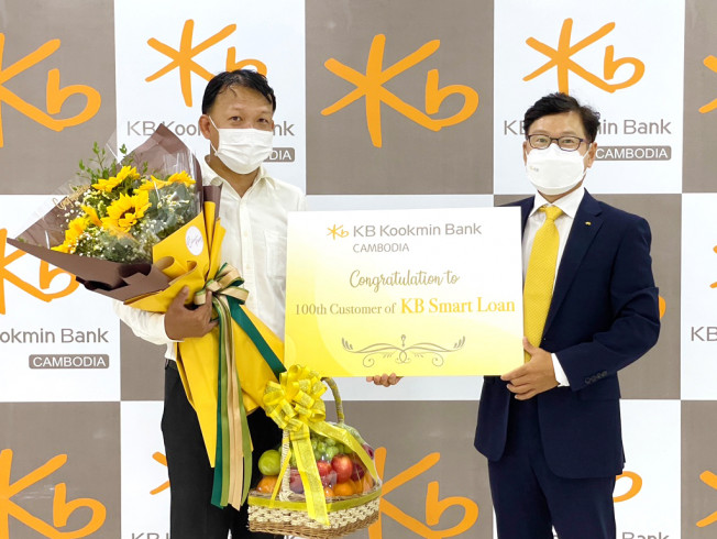 ▲KB캄보디아은행 본점에서 열린 KB스마트론 신규고객 기념 행사에서 (오른쪽)장용재 KB캄보디아은행 법인장과 고객이 기념촬영을 하고 있다. 