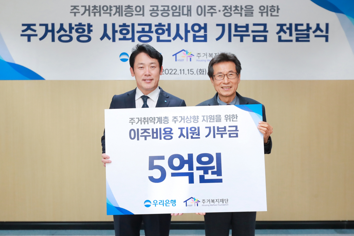 ▲심기우 우리은행 부동산금융그룹장(왼쪽)과 장경수 주거복지재단 대표이사가 15일 주거복지재단에서 열린 주거상향 사회공헌사업 기부금 전달식에서 기념촬영을 하고 있다. (사진제공=우리은행)