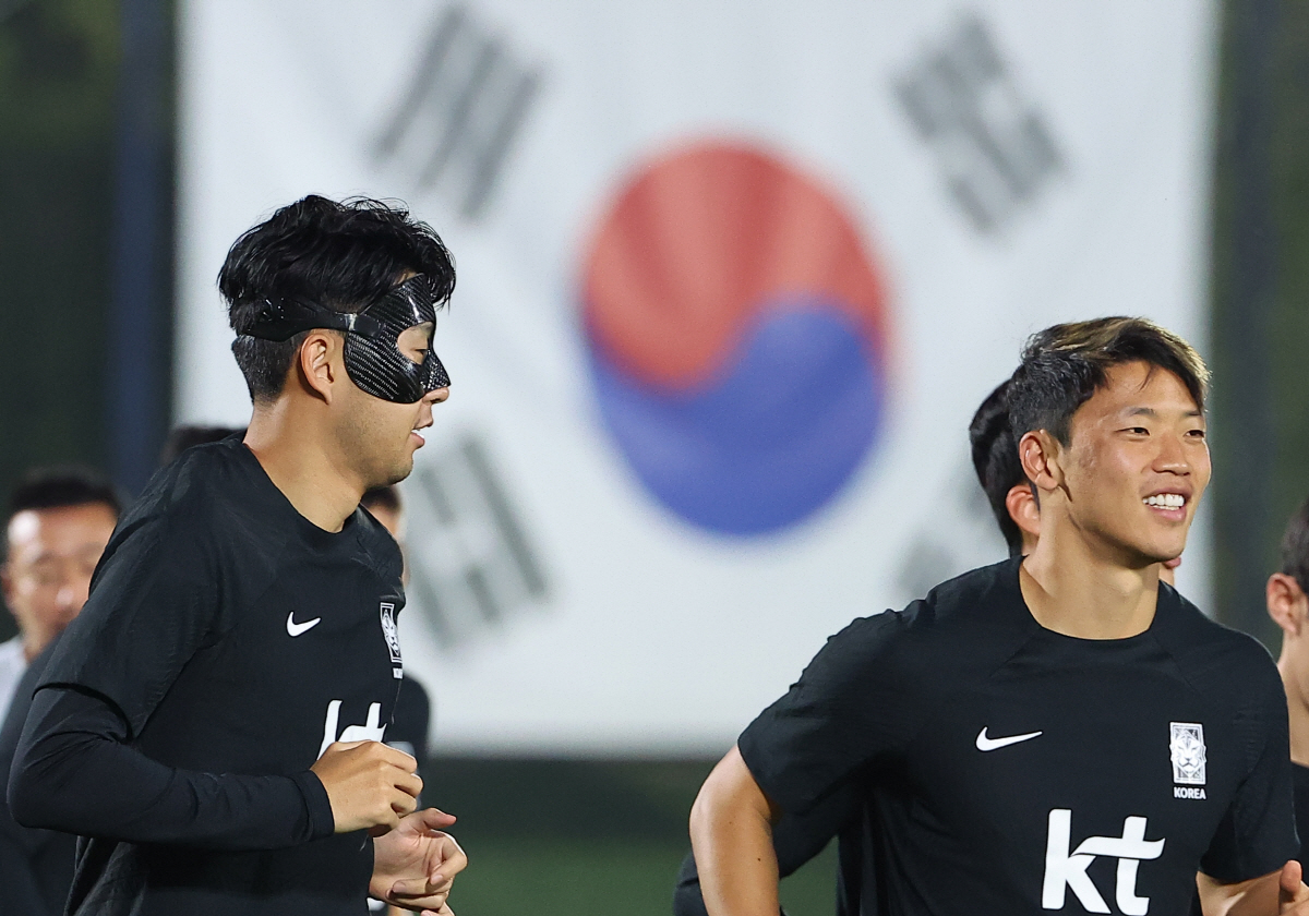 ▲'2022 카타르 월드컵'에 출전한 손흥민(왼쪽)과 황희찬이 18일 카타르 도하 알에글라 훈련장에서 운동장을 뛰며 몸을 풀고 있다. (연합뉴스)