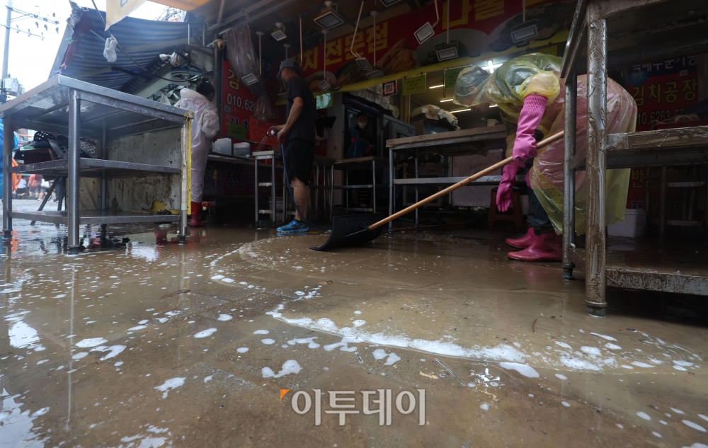 ▲서울 동작구 남성사계시장에서 수도권 일대에 내린 폭우로 침수 피해를 본 상인들이 집기 등을 정리하고 있다. 조현욱 기자 gusdnr8863@