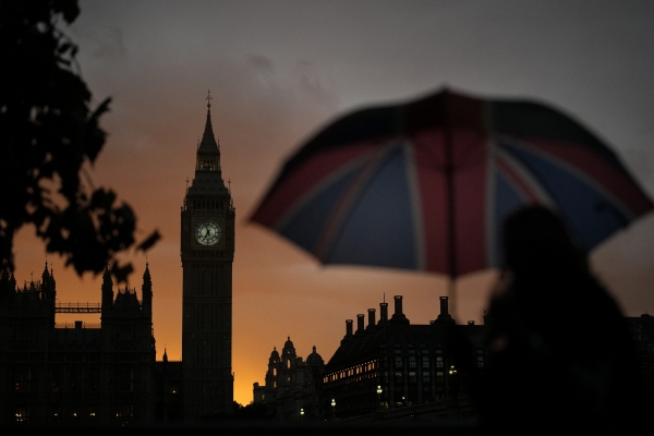▲영국 런던 빅벤 뒤로 석양이 보이는 가운데 한 여성이 영국 국기 모양이 담긴 우산을 들고 있다. 런던(영국)/AP뉴시스
