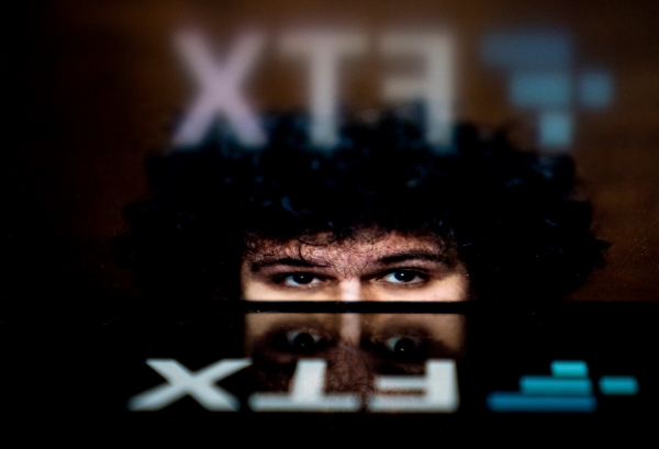▲FTX 창업자인 샘 뱅크먼 프리드의 사진과 FTX 회사 로고가 겹쳐보인다. FTX는 19일(현지시간) 해외 자산 매각을 위한 절차에 돌입했다고 밝혔다. AFP연합뉴스
