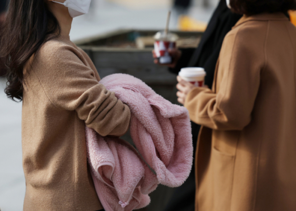 ▲21일 오후 겉옷을 손에 든 시민들이 광화문네거리를 지나고 있다. (연합뉴스)