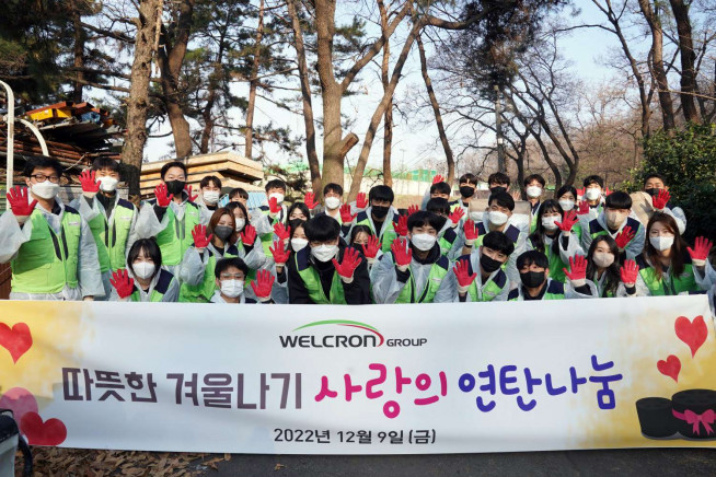 ▲지난 9일 인천 학익동 일대에서 연말 연탄나눔 봉사활동에 나선 웰크론그룹 임직원들이 연탄과 겨울 침구를 전달하고 기념촬영을 하고 있다.  (자료 = 웰크론)