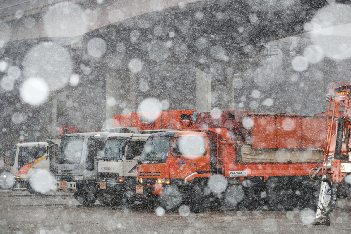 ▲13일 오후 서울 송파구 제설전진기지에서 제설차량이 제설제를 싣기 위해 대기하고 있다.   (뉴시스)