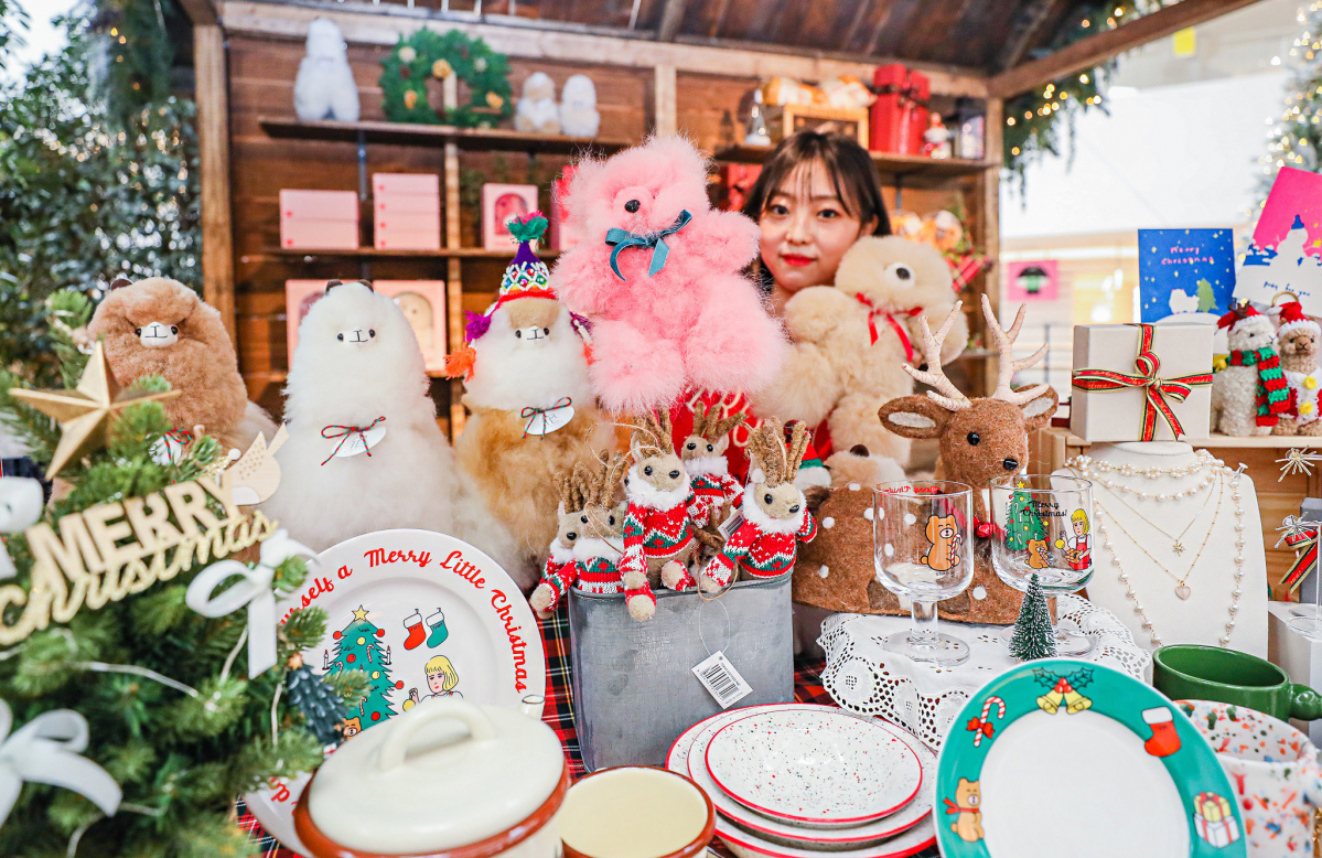 ▲서울 영등포구 더현대 서울 5층 사운즈포레스트에서 진행되는 '크리스마스 마켓'에서 직원이 크리스마스 시즌 상품들을 소개하고 있다. (사진제공=현대백화점)