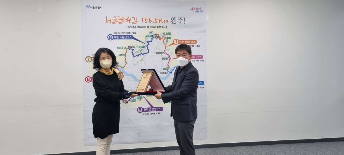 ▲유영봉 푸른도시여가국장이 6만 번째 완주자 김화자 씨에게 인증패를 전달하고 있다.  (사진제공=서울시)