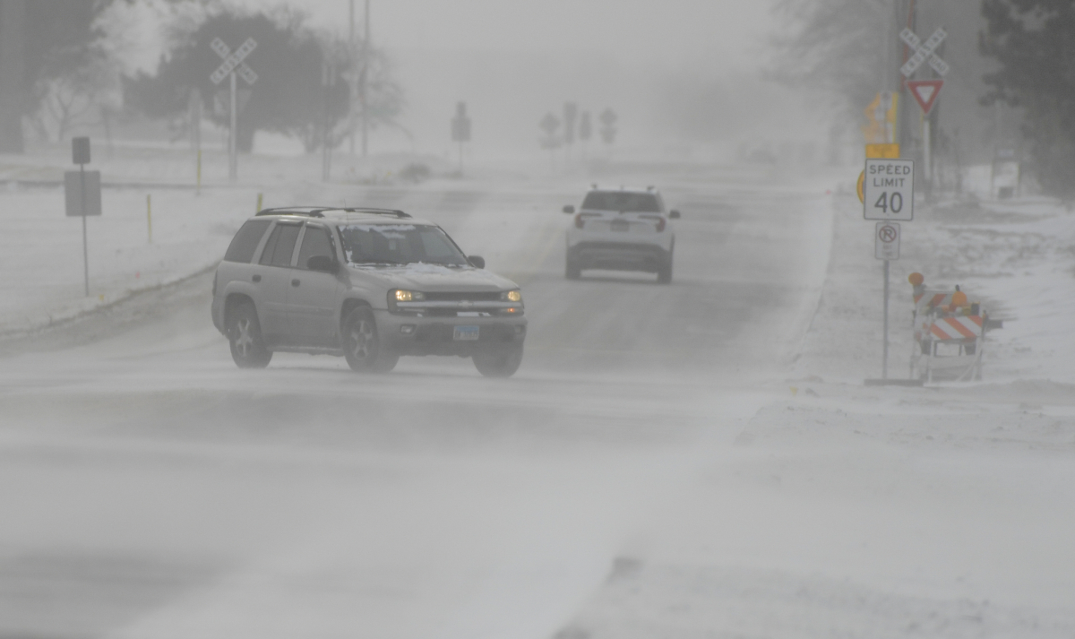 ▲일리노이주 시카고 외곽지역인 세인트찰스의 한 도로에서 23일(현지시간) 시속 20~30마일 강풍이 부는 가운데 차들이 눈길을 가로 질러 가고 있다. 세인트찰스/UPI연합뉴스