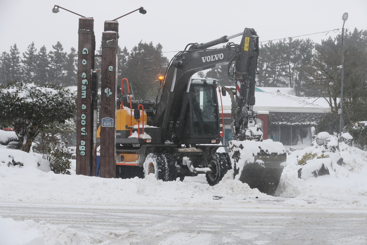 ▲제주도 전역에 폭설이 내린 23일 오후 제주시 조천읍 교래리의 한 식당 입구에서 굴삭기가 쌓인 눈을 치우고 있다. (연합뉴스)