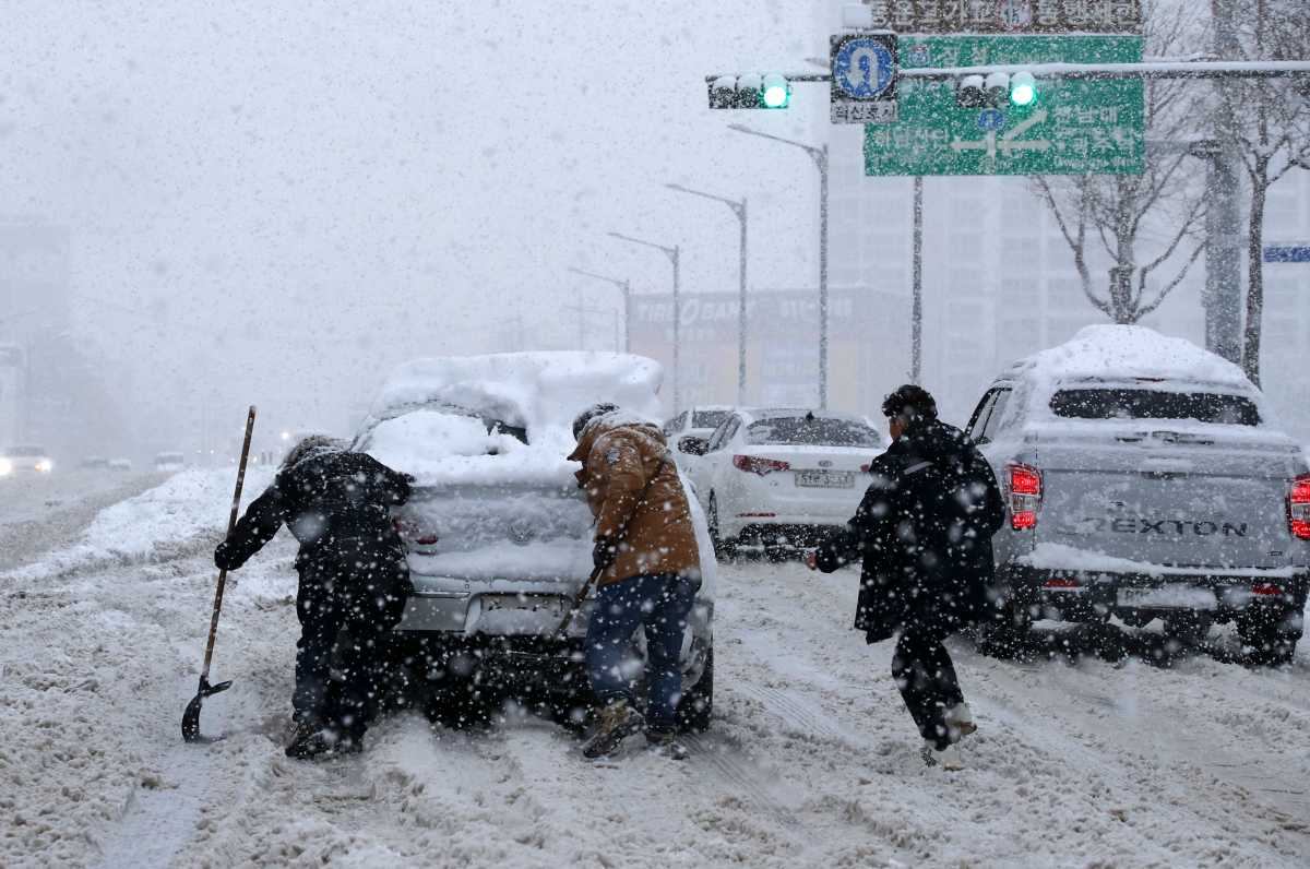 ▲광주ㆍ전남 지역에 폭설경보가 발효된 23일 광주 서구 죽봉대로에서 시민들이 눈길을 빠져나가지 못하고 있는 차량을 밀고 있다. (연합뉴스)