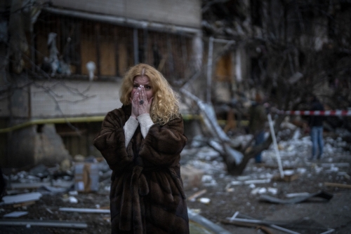 ▲2월 25일(현지시간) 우크라이나 키이우에서 한 여성이 러시아의 로켓 공격으로 파손된 자신의 집 근처에 서서 흐느끼고 있다. 키이우/AP뉴시스
