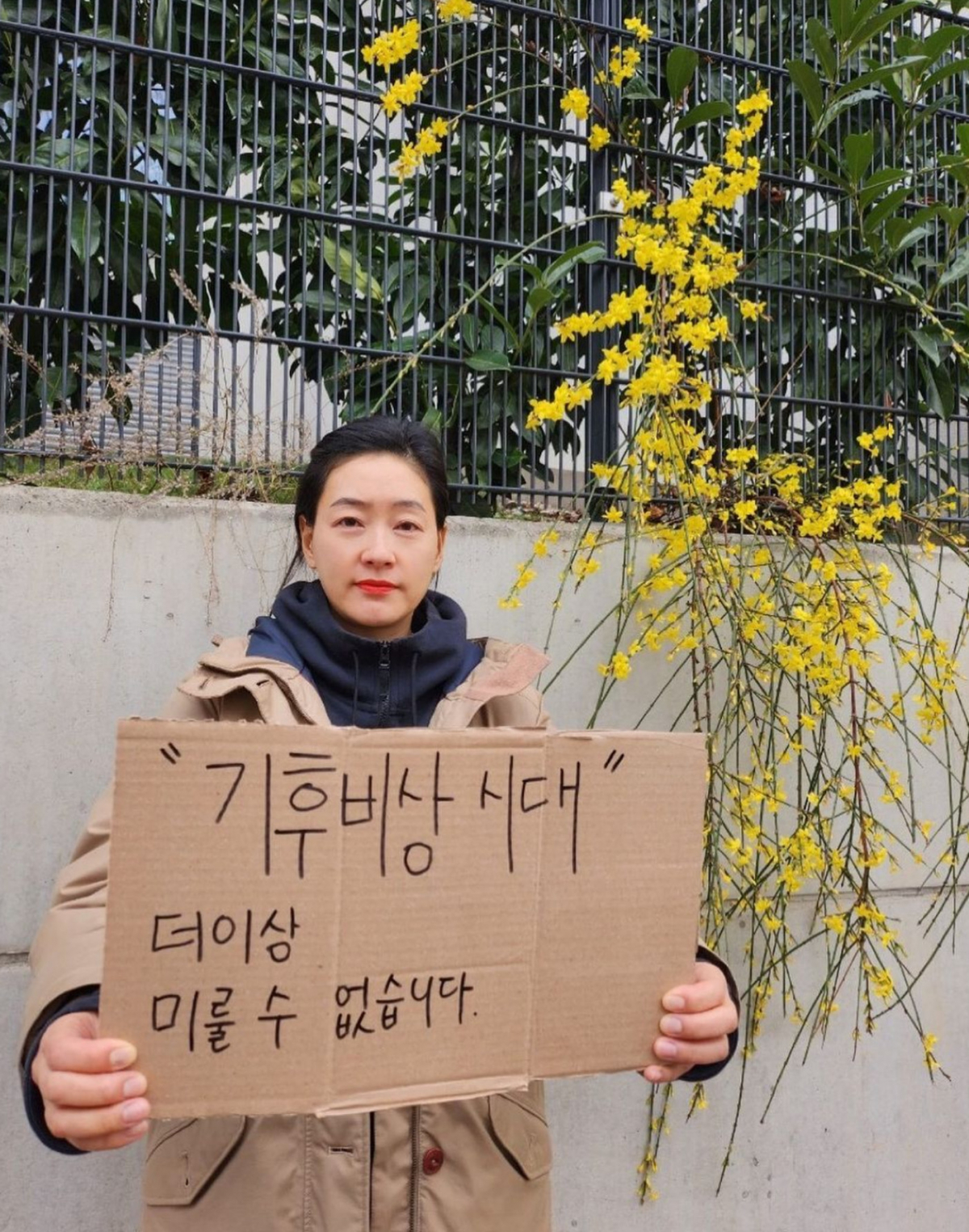 ▲박진희가 1월에 핀 개나리 앞에서 '기후 위기'를 강조하고 있다. (출처=박진희SNS)